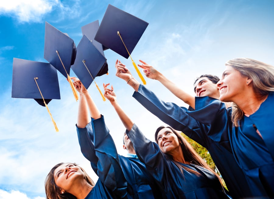 Students throwing graduation hats in the air celebrating