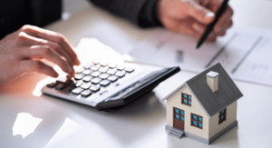 Individual using calculator and filling out documents for home