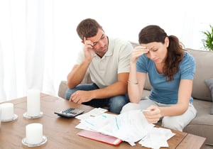 Worried couple doing their accounts in the living room at home