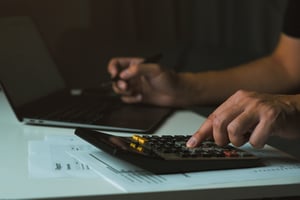 Man using a calculator to calculate expenses