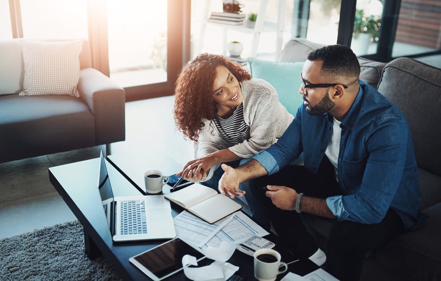 Couple on couch working on budgeting