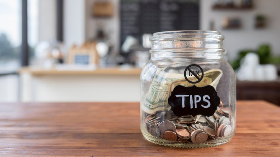 Glass tip jar labeled “No Tax on Tips” representing new tax changes for Texas service workers.