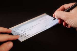 Person Writing a check for a charitable donation